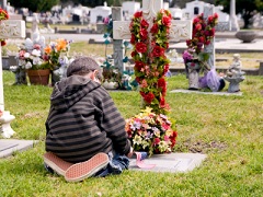 child kneeling at grave