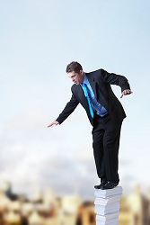 man stressed standing on high pile books